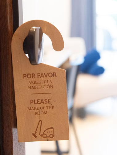 Puerta con cartel de "Por favor, arregle la habitación".