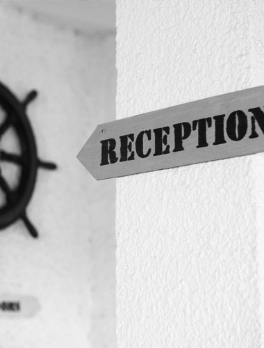 Señal de recepción en la pared del hotel Don Carlos, entrada principal.