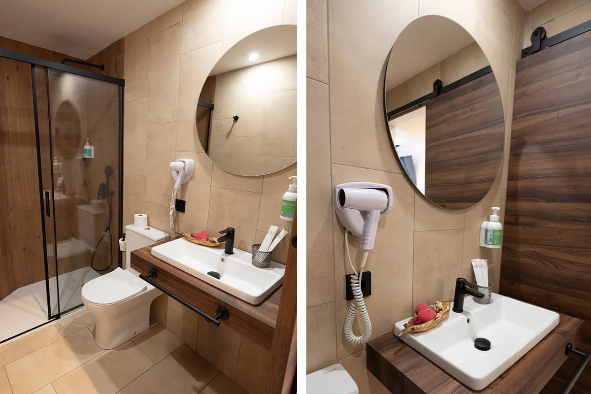 Baño con lavabo, espejo y ducha en Hotel Don Carlos, alojamiento en la Costa del Sol.