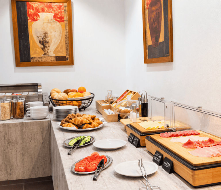 Buffet de desayuno con frutas, embutidos y panes en Hotel Don Carlos.